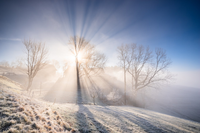 Reinerhof mit Sonnenstrahlen im Nebel